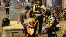 TOPSHOT - A young woman reacts as she speaks to Israeli rescuers in Tel Aviv, after a was hit by a rocket fired by Palestinian militants from the Gaza Strip on October 7, 2023. Palestinian militant group Hamas launched a surprise large-scale attack against Israel on October 7, firing thousands of rockets from Gaza and sending fighters to kill or abduct people as Israel retaliated with devastating air strikes. (Photo by JACK GUEZ / AFP)