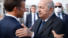 French President Emmanuel Macron (L) talks with Algeria's President Abdelmadjid Tebboune (R) at Algiers airport, in Algiers, on August 27, 2022. - Emmanuel Macron is on a three-day visit to Algeria aimed at mending ties with the former French colony, which this year marks its 60th anniversary of independence. (Photo by Ludovic MARIN / AFP)